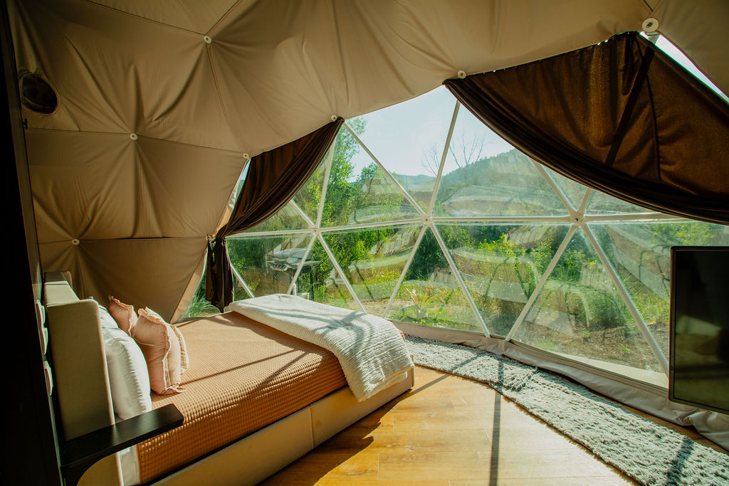 Inside the River Dome — geodesic dome interior with panoramic canyon views and cozy bed
