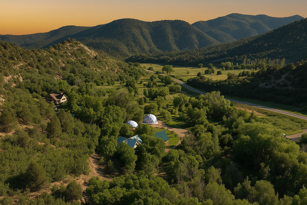 Aerial view of Zen Zion property with geodesic domes nestled among trees at golden hour